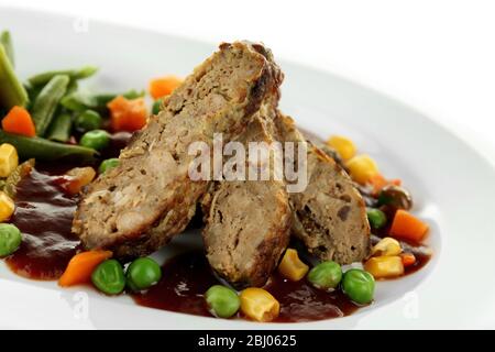 Fette di carne saporite con verdure sul piatto da vicino Foto Stock