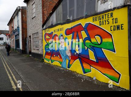 Derby, Derbyshire, Regno Unito. 28 aprile 2020. Una donna cammina verso Covid-19 correlato Street art durante il blocco pandemico coronavirus. Credit Darren Staples/Alamy Live News. Foto Stock