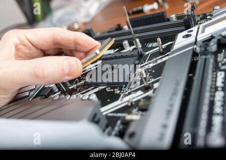 Tecnico informatico installazione di CPU nella scheda madre. Close up. Foto Stock