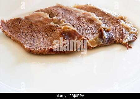 Tre fette di mutone bollito su piatto bianco. Ritorno di un classico britannico, non apprezzato per molti anni, ma ora mutton è nuovamente disponibile da seriou Foto Stock