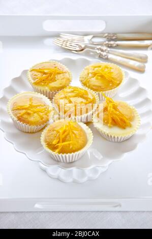 Sei torte fata al limone con gocce di limone su supporto per torte bianche - Foto Stock
