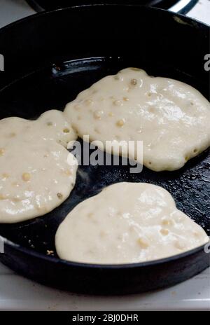 Cottura delle frittelle di mais in padella di ghisa pesante. - Foto Stock