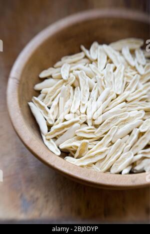 Forme crude di cicatelli, in vecchio recipiente di legno su superficie in legno - Foto Stock