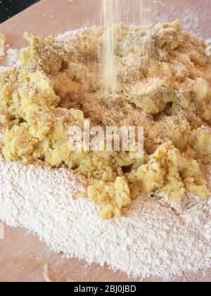 Mescolando patate pressate e parmigiano grattugiato in farina per produrre gnocchi. Foto Stock