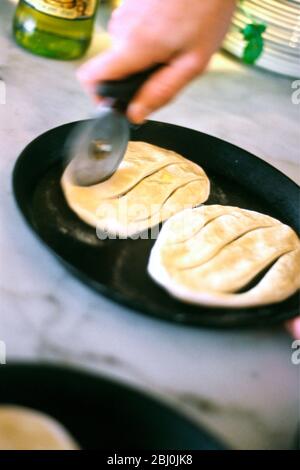 Pasta per pizza arrotolata con olio d'oliva tagliato in forma prima di cuocere come focaccia - Foto Stock