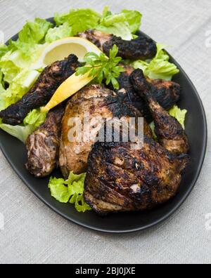 Zampe di pollo alla griglia sul plater con insalata all'aperto - Foto Stock