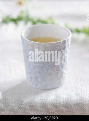 Piccola tazza di porcellana di tè alle erbe di camomilla - Foto Stock