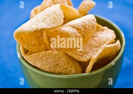 Cracker di gamberi tailandesi in terrina verde su tela blu - Foto Stock