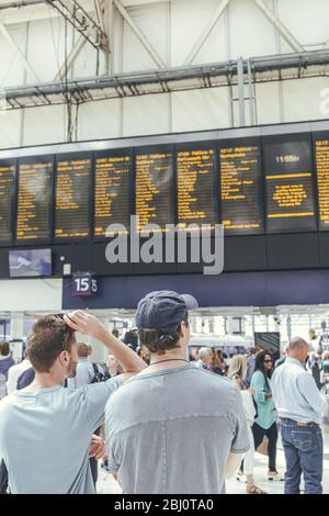 Londra/UK-1/8/19:giovani uomini in attesa del loro treno alla stazione di London Waterloo in un'ora di punta. Terminal del centro di Londra sulla rete ferroviaria nazionale Foto Stock