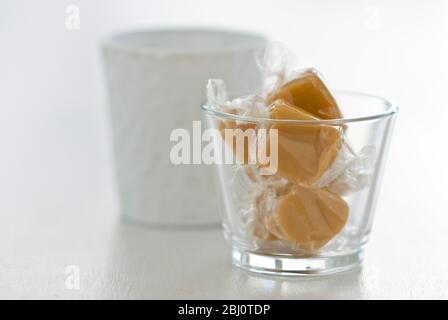 Qualche caramella avvolta in cellophane in una pentola di vetro - Foto Stock