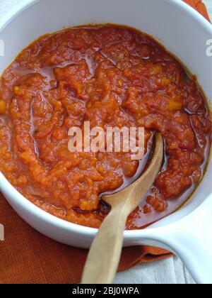 Salsa di pomodoro fresca fatta in casa in pentola bianca in ceramica con cucchiaio di legno - Foto Stock