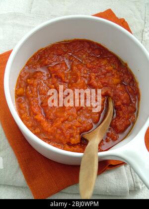 Salsa di pomodoro fresca fatta in casa in pentola bianca con cucchiaio di legno - Foto Stock