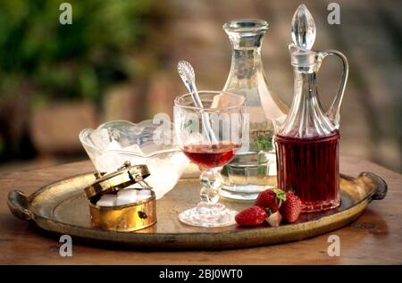 Preparazione di una fragola cordiale utilizzando vecchio vetro su vassoio di doratura fiorentina - Foto Stock