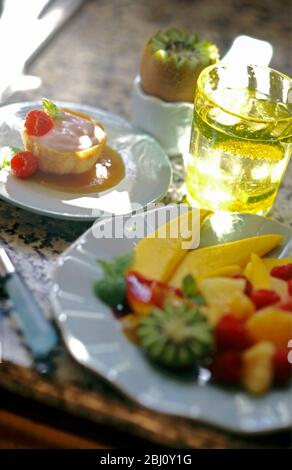 Dessert estivi - piatto di frutta e mousse di fragole in pasticceria e kiwi vandicciati in coppa di melanzane - Foto Stock