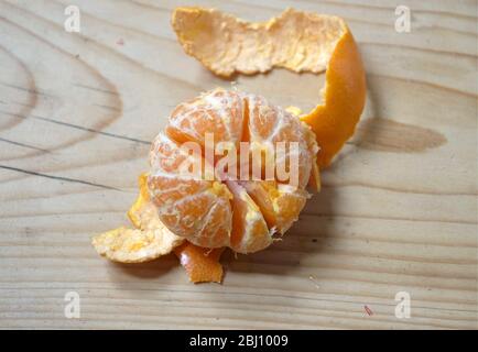 satsuma pelata su tavolo in legno - Foto Stock