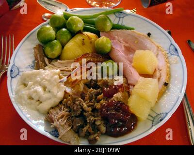 Cena di Natale completa con tacchino, prosciutto, salsa di pane, farcitura, cavolini di bruxelles, sausagemeat, ananas, patate arrosto, salsa di mirtilli su dani Foto Stock