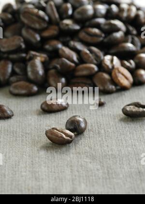 Mucchio di chicchi di caffè tostati scuri su tela - Foto Stock