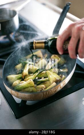 Cottura dei pakchoi in olio di sesamo caldo e cosparso di salsa di soia - Foto Stock