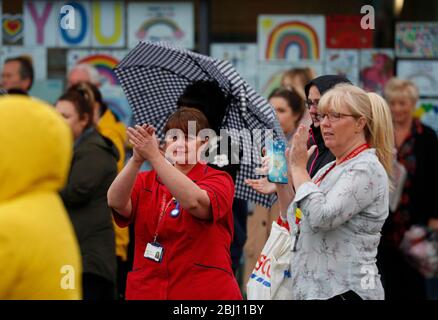 Derby, Derbyshire, Regno Unito. 28 aprile 2020. Il personale del Royal Derby Hospital e i membri del pubblico applaudono dopo un silenzio di minuteÕs per ricordare i lavoratori chiave che sono morti a causa di Covid-19 durante il blocco pandemico del coronavirus. Credit Darren Staples/Alamy Live News. Foto Stock