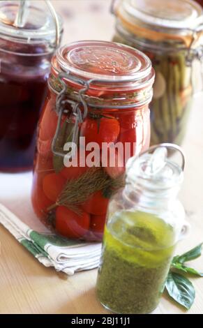 Home preservazione - fagioli verdi imbottigliati e pomodori con pesto e chutney - Foto Stock