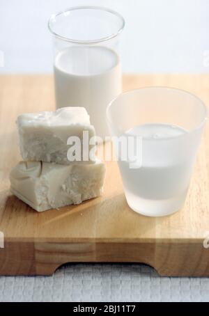 blocco di cocco con crema, e bicchieri di latte di cocco e crema - Foto Stock