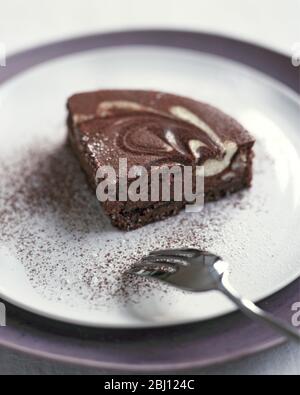 Porzione di crostata di cioccolato su piatto con cucchiaio - Foto Stock