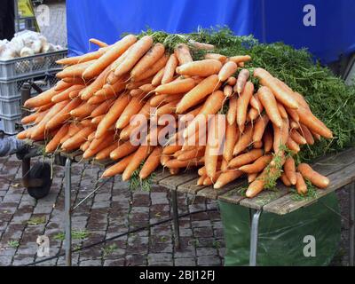 Un grosso mucchio di carote appena scavate in vendita su un tavolo nel mercato di Varberg, ottobre. Svezia - Foto Stock