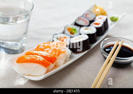 Piatto di sushi giapponese tradizionale. Hosomaki e makizushi con vari ripieni, nigiri con salmone e gamberi Foto Stock