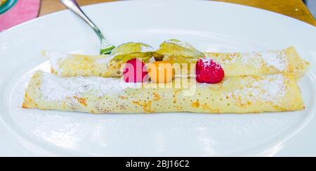 crepes ripieno di cioccolato e bacche con fragole selvatiche e gooseberi di capo Foto Stock