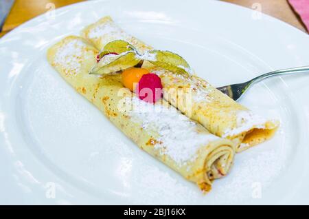 crepes ripieno di cioccolato e bacche con fragole selvatiche e gooseberi di capo Foto Stock