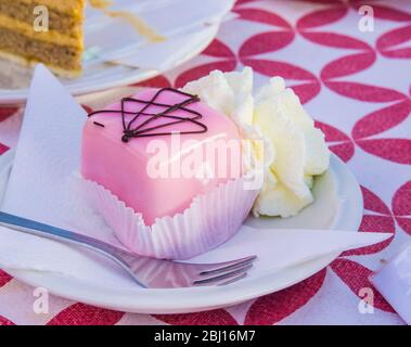 torte alla vaniglia e alla spugna di cioccolato con glassa di fragole servite con panna montata Foto Stock