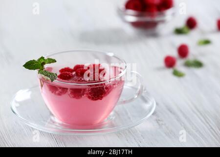 Tazza di bevanda lampone con frutti di bosco su tavolo di legno primo piano Foto Stock