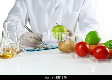 Scienziato esamina verdure in laboratorio Foto Stock