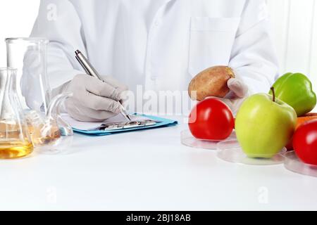 Scienziato esamina verdure in laboratorio Foto Stock