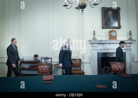 Il primo ministro Boris Johnson (al centro) arriva con il segretario del Gabinetto, Mark Sedwill (a sinistra) e il cancelliere Rishi Sunak (all'estrema destra) nella Sala del Gabinetto all'interno di 10 Downing Street, Londra, per osservare un minuto di silenzio in omaggio al personale dell'NHS e ai principali lavoratori morti durante l'epidemia di coronavirus. Foto PA. Data foto: Martedì 28 aprile 2020. Vedi la storia della PA SALUTE Coronavirus Silence. Il credito per le foto dovrebbe essere: Stefan Rousseau/PA Wire Foto Stock