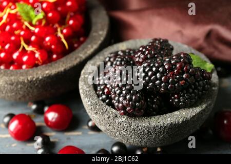 Frutti di bosco in ciotole su sfondo di legno Foto Stock