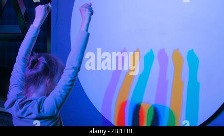 Esposizione interattiva nel museo della scienza. Ombre colorate di donna danzante. Concetto di scienza, ottica e fisica Foto Stock