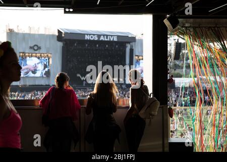 Amici su un balcone che si affaccia sul palco principale del Festival di musica EDP NOS Alive, ad Alges, Lisbona, Portogallo. Foto Stock