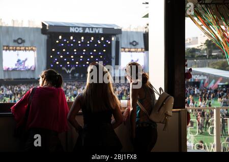 Amici su un balcone che si affaccia sul palco principale del Festival di musica EDP NOS Alive, ad Alges, Lisbona, Portogallo. Foto Stock