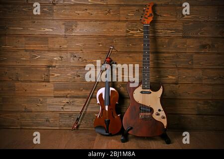Elettrico e violino su sfondo legno Foto Stock