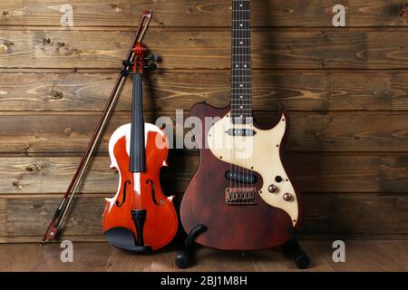 Elettrico e violino su sfondo legno Foto Stock
