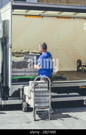 Londra/UK-1/08/18: Uomo che scarica la London Evening Standard al quadrante di Richmond. Lo Standard serale è un quotidiano locale, gratuito, in città Foto Stock