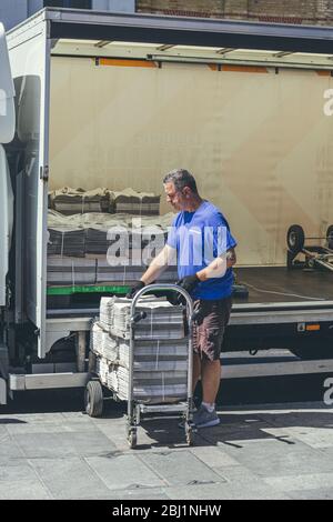 Londra/UK-1/08/18: Uomo che scarica la London Evening Standard al quadrante di Richmond. Lo Standard serale è un quotidiano locale, gratuito, in città Foto Stock