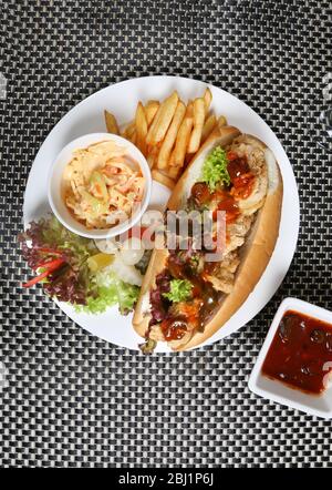Sandwich di pollo Zinger con coleslaw e patate fritte Foto Stock