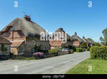 Fila di cottage con tetto di paglia nel pittoresco villaggio di East Stratton in Hampshire, Inghilterra, Regno Unito Foto Stock