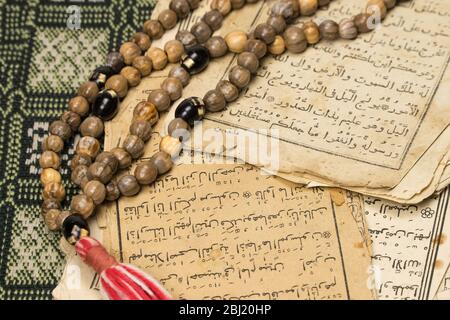 Perline di preghiera musulmana con pagine antiche del Corano. Concetti islamici e musulmani. Antichi fogli di carta del libro arabo Foto Stock