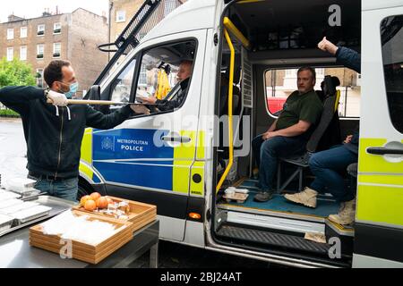 Cibo e bevande vengono trasferiti in un pulmino della polizia, a un drive-through gratuito per i servizi di emergenza al Berkeley Hotel mentre il Regno Unito continua a chiudere a chiave per contribuire a frenare la diffusione del coronavirus. Foto Stock