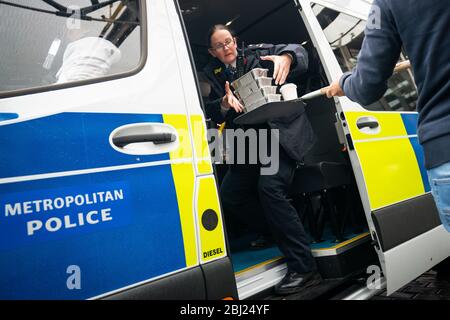 Cibo e bevande vengono trasferiti in un pulmino della polizia, a un drive-through gratuito per i servizi di emergenza al Berkeley Hotel mentre il Regno Unito continua a chiudere a chiave per contribuire a frenare la diffusione del coronavirus. Foto Stock