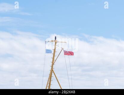 NHS, Thank You Heroes bandiera, con il cartello rosso che vola su Mast su Calmac Ferry Lord of the Isles in South Uist Outer Ebrides, Scozia Foto Stock