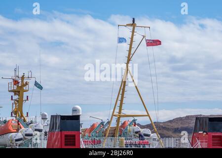 NHS, Thank You Heroes bandiera, con il cartello rosso che vola su Mast su Calmac Ferry Lord of the Isles in South Uist Outer Ebrides, Scozia Foto Stock